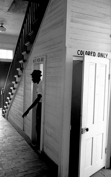 An African American man emerges from using the White Men Only bathroom at courthouse in Clinton, Louisiana, 1964. Photo credit Bob Adelman Corbis