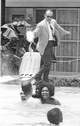 Hotel owner pouring acid in the water when black people swam in his pool, ca. 1964
