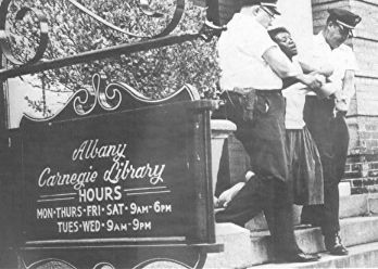 Woman arrested for trying to read a book in a segregated library in Albany, GA. 1962.