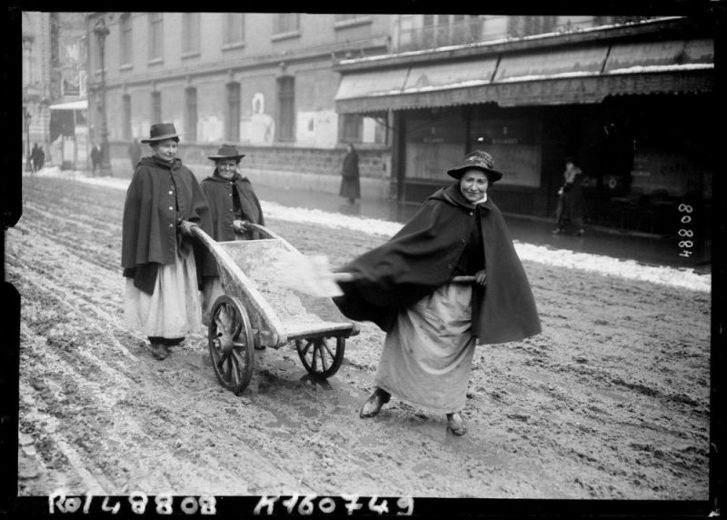Women shovelling snow from the road Paris France