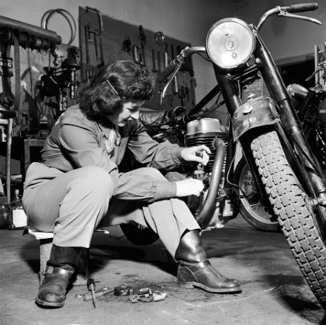 Repairing her motorbike, 1950