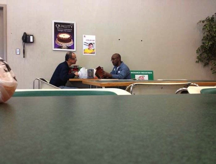 A man spends his lunch break reading to a coworker who's unable to read.