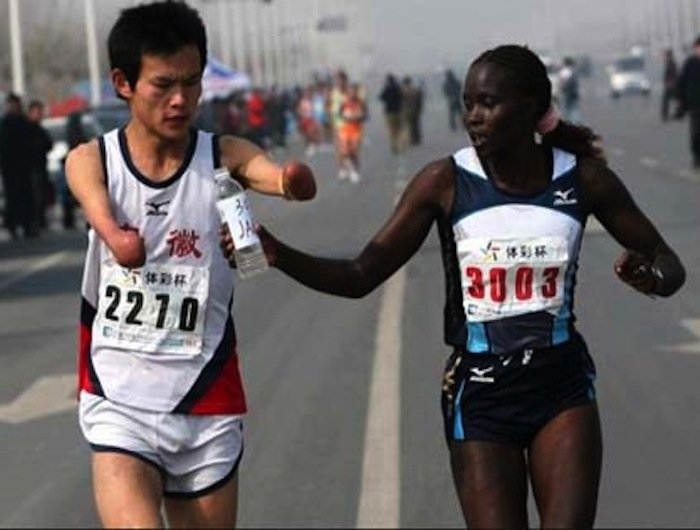 A world-class marathon runner slows down to help a disabled man open his bottle of water.