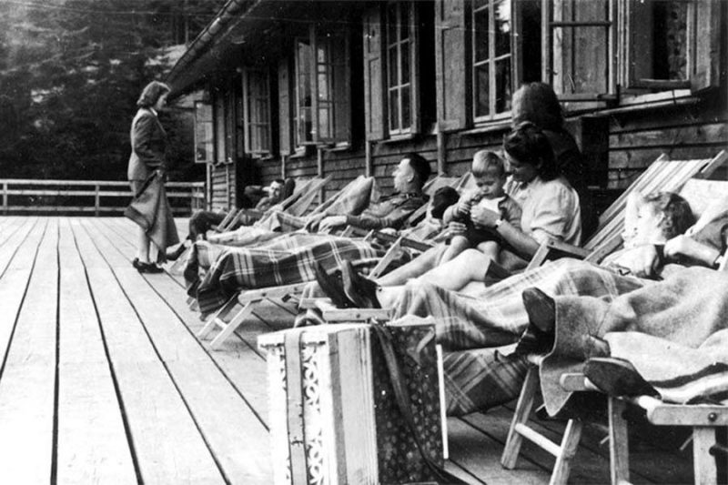 SS officers relax together with women and a baby on a deck at Solahütte.