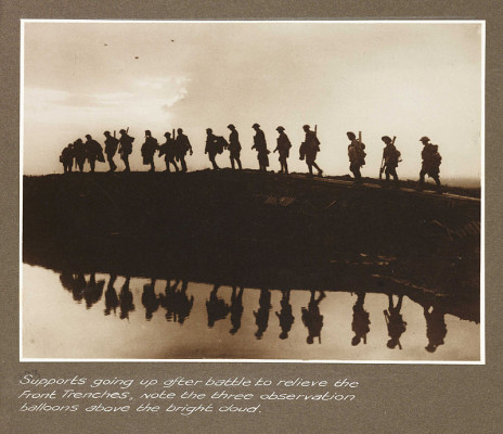 Supports_going_up_after_battle_to_relieve_the_front_trenches,_note_the_three_observation_balloons_above_the_bright_cloud_(3007981750)