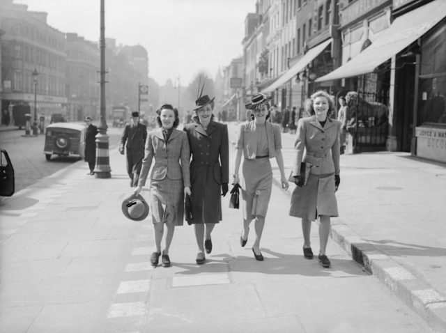 Women walk down a London street during the Second World War in 1941.
