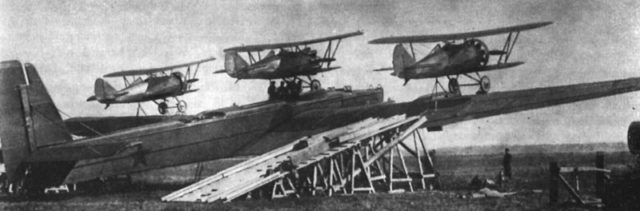 Zveno-2: Tupolev TB-3 and three Polikarpov I-5. Also visible is the ramp for loading the fighters. The centerline aircraft was hoisted on top of the fuselage by hand. source