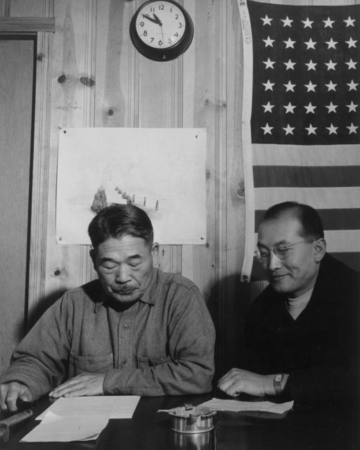 Roy Takeno, right, and the mayor of the camp at a town hall meeting.