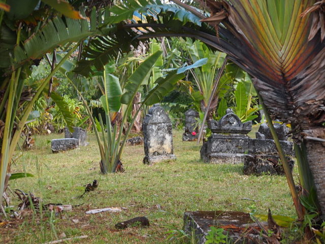 The crumbling cemetery, its graves half covered by tall, swaying grass, is open to the public. Source