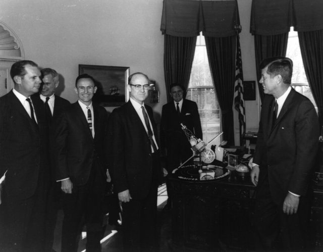 William H. Pickering, (center) JPL Director, President John F. Kennedy, (right). NASA Administrator James E. Webb (background) discussing the Mariner program, with a model presented. source