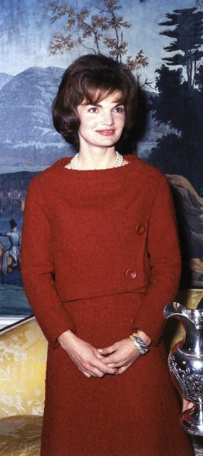 First Lady Jacqueline Kennedy wearing a red wool dress with matching jacket. She was a fashion icon in the early 1960s.Source