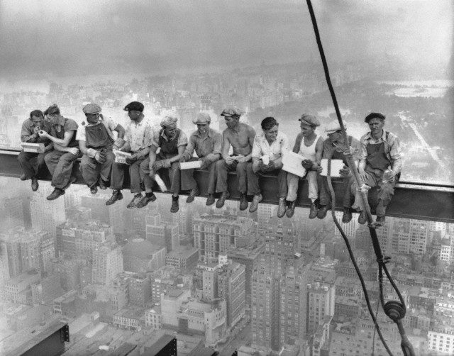 29 Sep 1932 --- Construction workers eat their lunches atop a steel beam 800 feet above ground, at the building site of the RCA Building in Rockefeller Center. --- Image by © Bettmann/CORBIS