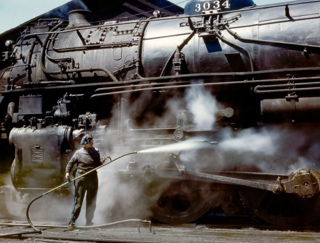 Mrs. Viola Sievers sprays an H-class locomotive with steam.