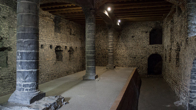 The “cellar”, where you can see remains of the original walls of the castle. Source