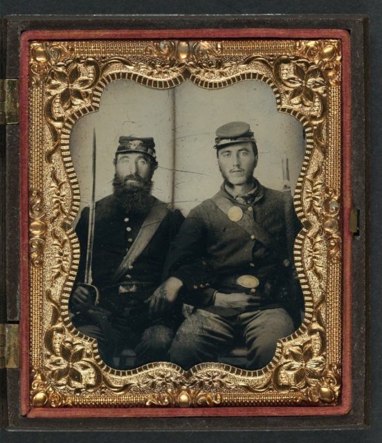 Two unidentified soldiers in Union uniforms and forage caps with saber and musket.