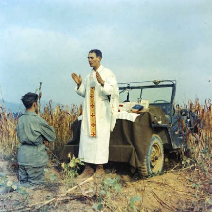 Father Emil Kapaun celebrating Mass using the hood of a jeep as his altar, October 7, 1950 Source Wikipedia Public Domain