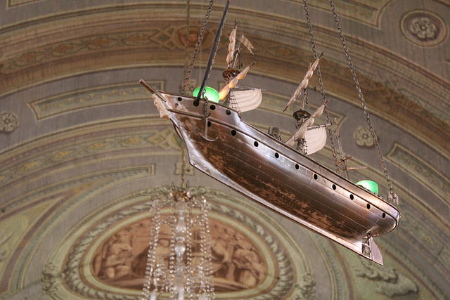 Model ships hang from the ceiling to honour the Virgin's protection.. Source