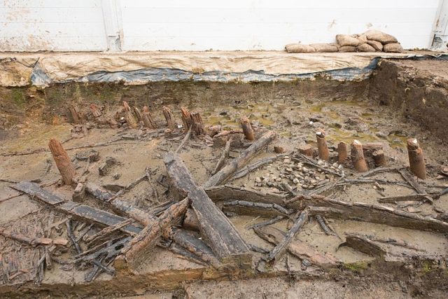 Remains of a house at Must Farm showing the unburnt stumps of posts under the waterline during the fire (top-right) and collapsed joists Photo Credit
