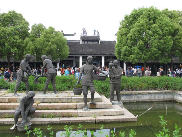 Riverside sculptures with the characters “Wuzhen“ in the background. By Fanghong/CC BY-SA 3.0 