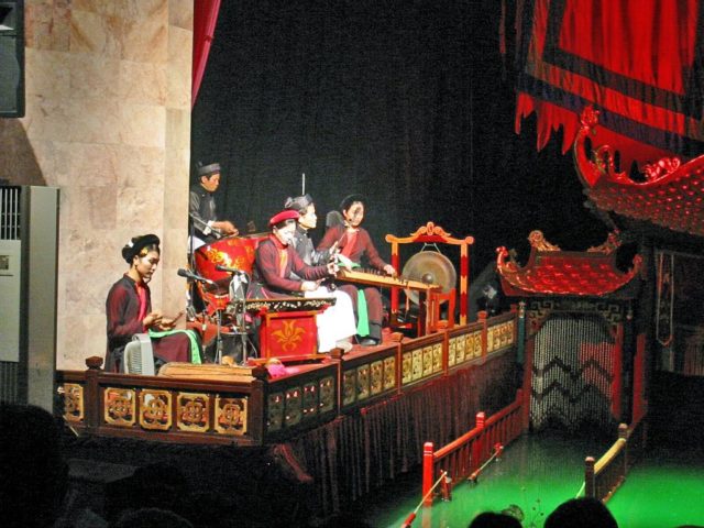 The orchestra accompanies the performance with traditional music. Source