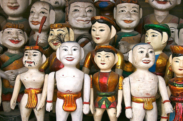 The puppets are made out of wood and then lacquered. Source