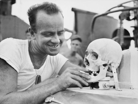 Lieutenant (junior grade) E. V. Mcpherson, of Columbus, Ohio with a Japanese skull which serves as a mascot aboard the US Navy motor torpedo boat 341. Source: Wikipedia / Public Domain
