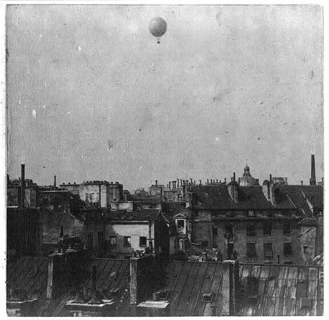 Ballon of Henri Giffard over Paris rooftops, 1878. Image by- Unknown- Library of Congress. Wikipedia. Public Domain