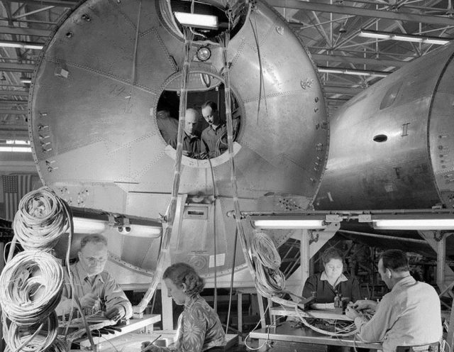 Employees running cabling for instrumentation and flight controls are being routed through this B-29's forward fuselage.