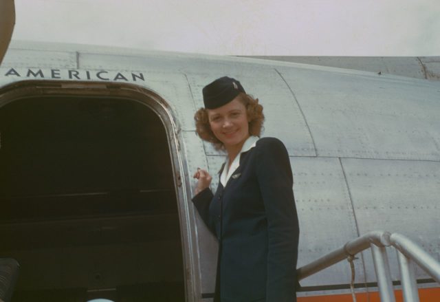 Flight attendant, circa 1949–1950, American Overseas Airlines, Flagship Denmark, Boeing 377 Stratocruiser By Photo by Chalmers Butterfield Original uploader was Sba2 at en.wikipedia - Photo by Chalmers Butterfield, CC BY 2.5, https://commons.wikimedia.org/w/index.php?curid=7955628
