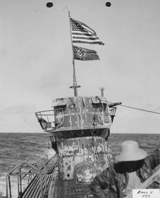 View of US and German colors flying over conning tower of U-505.