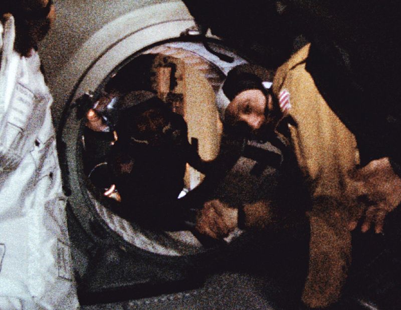 Astronaut Thomas P. Stafford and cosmonaut Aleksei Leonov shake hands in space to ease cold war tensions.
