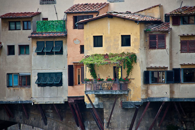 Some of the houses on the bridge have an extension hanging over the river, supported with long wooden shores, known as sporti. Photo Credit