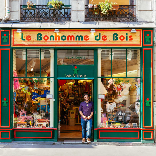Yann Bilhaud waits for children at the door of the toy shop he runs