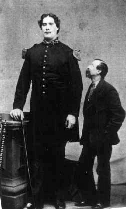 Bates in uniform next to a man of average height
