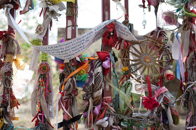 The graveyard gates have been decorated with votive messages, ribbons, flowers and other tokens as a voluntary act of remembrance by visitors. Photo Credit