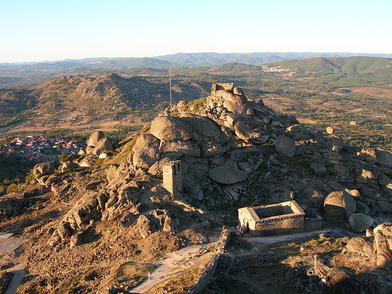 A view of the castle and walls draped over the hilltop of Monsanto (with the Chapel of Santa Maria do Castelo in the foreground). Photo Credit