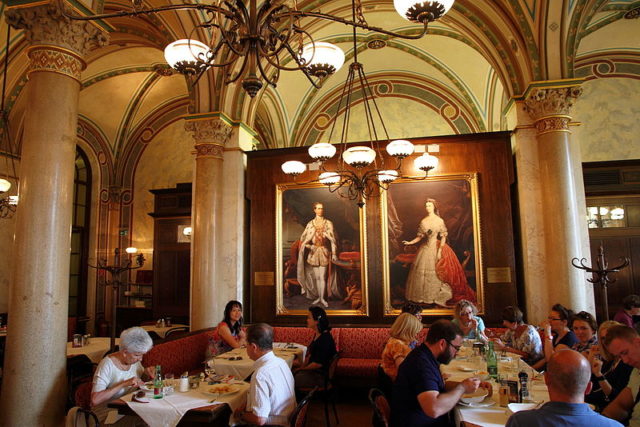 Cafe Central in Vienna interior near portraits of Empress Elisabeth of Austria and Franz Joseph I of Austria. Photo Credit