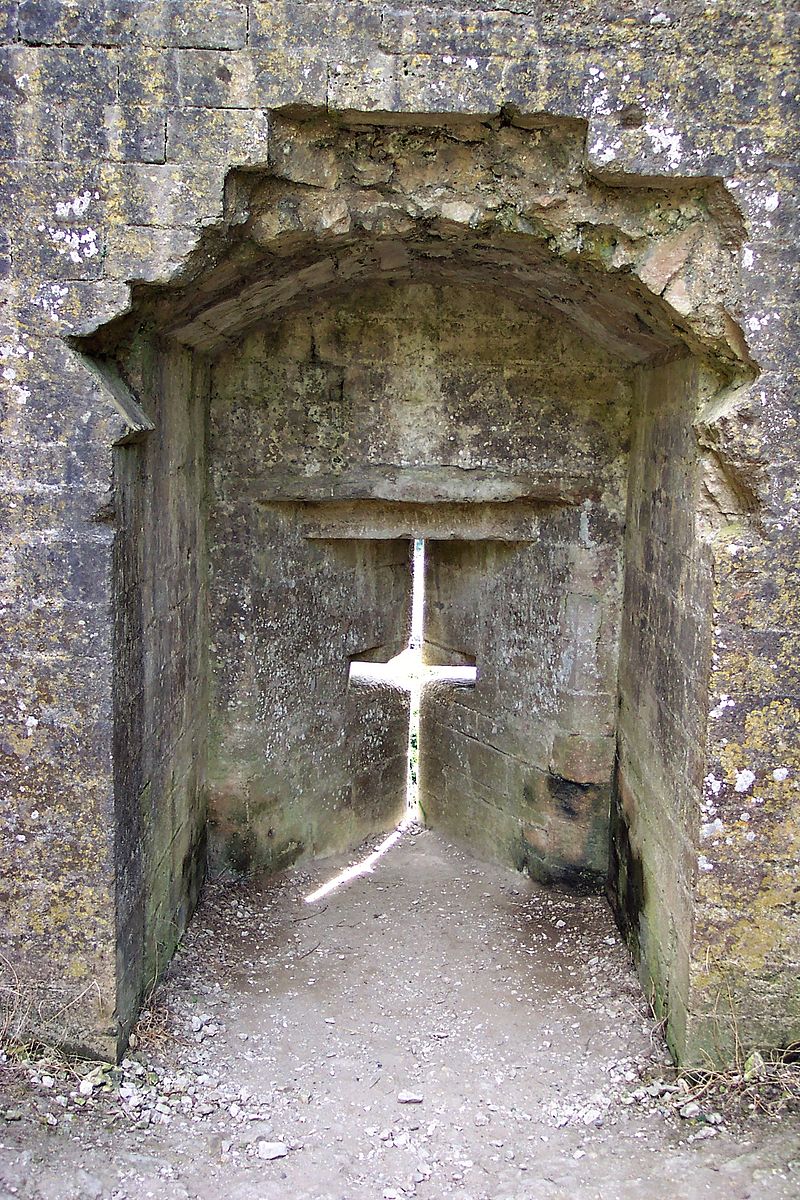 A loophole at Corfe Castle. This shows the inside where the archer would have stood. Author: John Bointon from Watford, UK – Flickr – CC BY 2.0