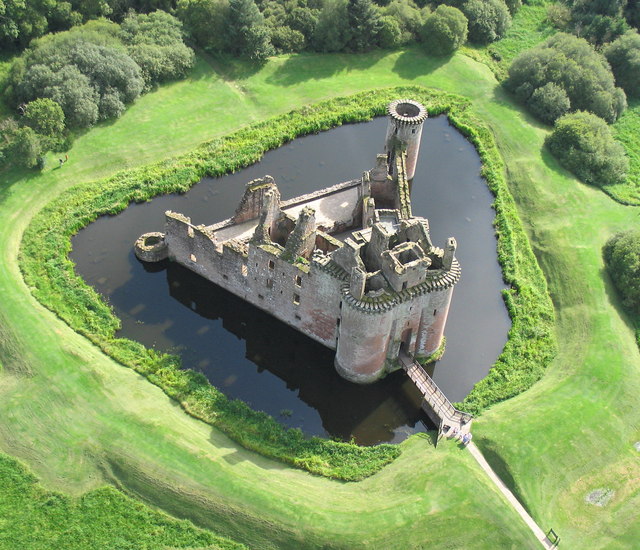 Caerlaverock Castle in Scotland is surrounded by a moat – a ditch filled with water. An aerial view of the 13th century stone building with a triangular plan. Photo Credit