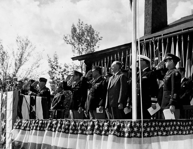 Presentation of the Army–Navy “E” Award at Los Alamos on 16 October 1945. Standing, left to right: J. Robert Oppenheimer, unidentified, unidentified, Kenneth Nichols, Leslie Groves, Robert Gordon Sproul, William Sterling Parsons.