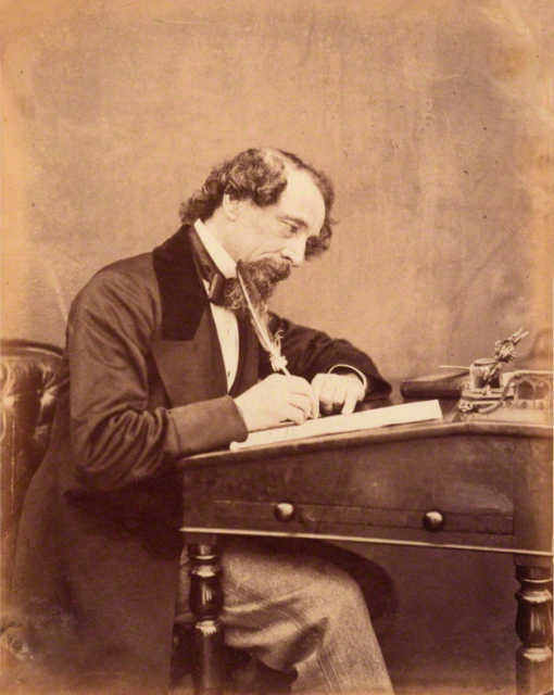 Charles Dickens writing at his desk in 1858.