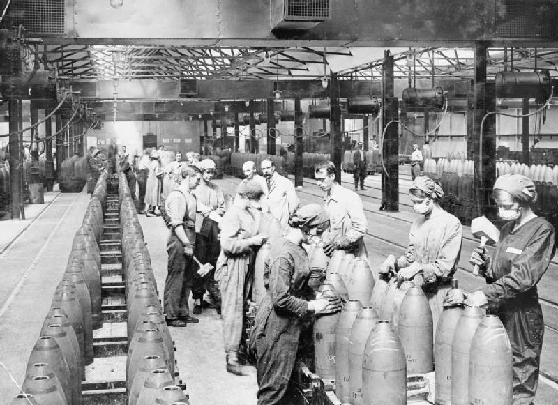 Men and women use wooden mallets to secure the tops of shells in the ‘Melting House’ of the National Filling Factory, Chilwell