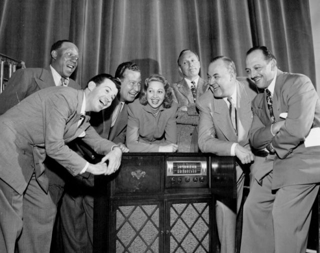 The cast of The Jack Benny Program, from left to right: Eddie Anderson, Dennis Day, Phil Harris, Mary Livingstone, Jack Benny, Don Wilson, and Mel Blanc