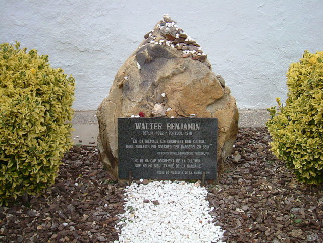 Walter Benjamin’s grave in Portbou. The epitaph in German, repeated in Catalan, quotes from Section 7 of Theses on the Philosophy of History: “There is no document of culture which is not at the same time a document of barbarism” Photo Credit