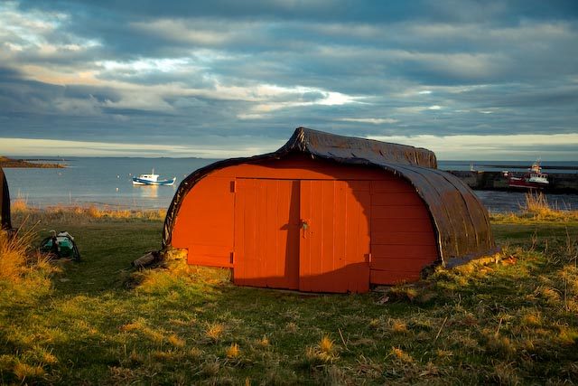 One of the boat sheds on the shore within the harbor on Holy Island. Photo Credit