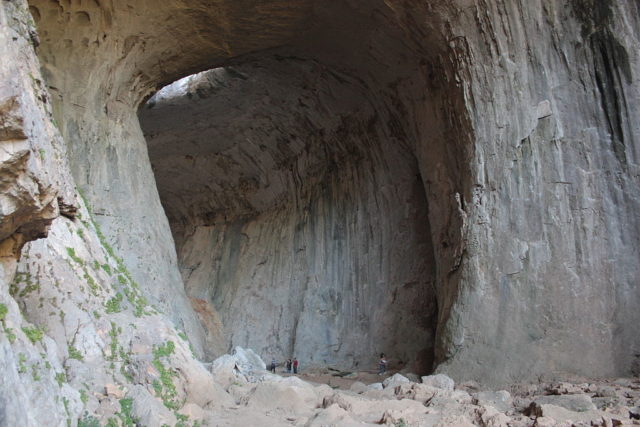 The Big Entrance of Prohodna (Passage) cave with visitors for comparison of height. Photo Credit