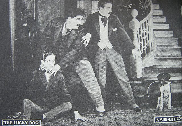 Lucky Dog (1921) – featuring the first appearance on film by Laurel and Hardy. Stan Laurel is seated with Oliver Hardy’s hands around his neck.