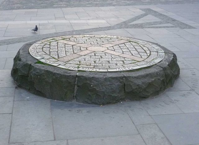 Grassmarket in Edinburgh: shadow of the gibbet delineated in paving on the site of public executions, next to the Covenanters Memorial from 1937.