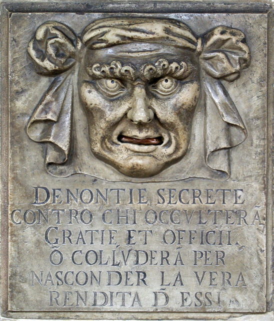 Lion’s Mouth Drop Slot for Anonymous Accusations, Doge’s Palace, Venice. Translation of the text reads: ““Secret denunciations against anyone who will conceal favors and services or will collude to hide the true revenue from them.”