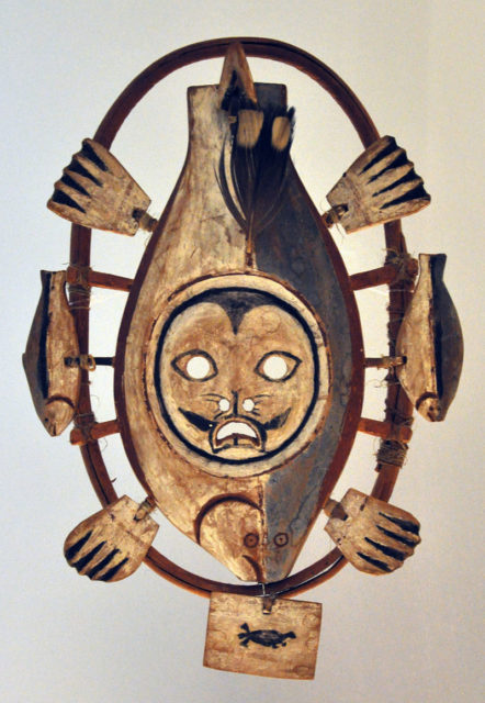 Wooden mask with the seal spirit in the middle, fish in the circle, and the hands are attached to the front and back with tendons, Hooper Bay, Alaska, 1930s